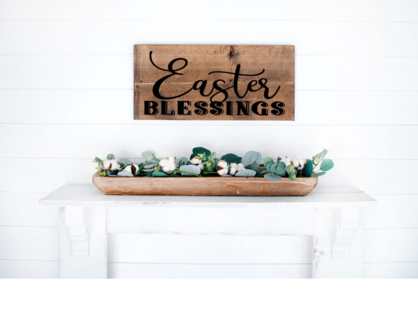 A 12x18 Easter Blessings wooden sign hangs on a white shiplap wall above a white mantel decorated with a tray of greenery and cotton stems. - Spruced Studio Upscale Workshop