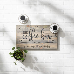 A 14x24 Coffee Bar sign is mounted on a white brick wall, accented by two coffee cups and a potted plant as props above and below it. - Spruced Studio Upscale Workshop