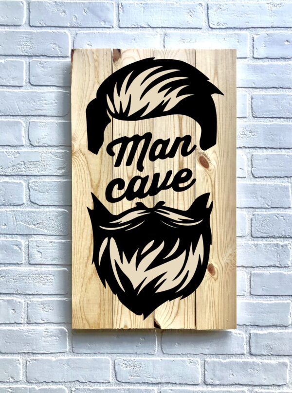 The 14x24 Man Cave (beard) is a wooden sign featuring black hair, mustache, and beard graphics with "Man cave" text, displayed on a white brick wall. - Spruced Studio Upscale Workshop