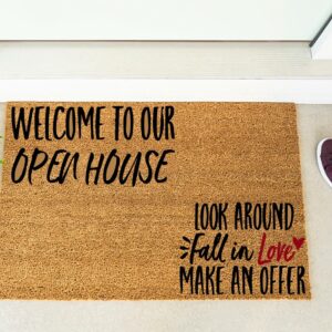 The "Welcome to Our Open House" doormat displays inviting messages and is shown next to maroon shoes and a plant by the door. - Spruced Studio Upscale Workshop