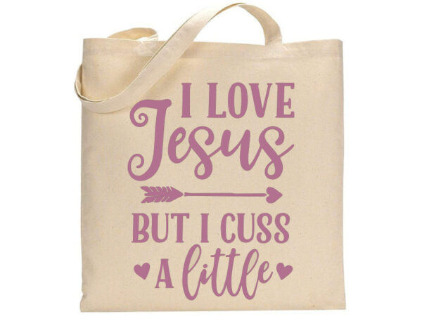 Beige "Love Jesus" tote bag with "I love Jesus but I cuss a little" printed in pink letters, decorated with hearts and an arrow. - Spruced Studio Upscale Workshop