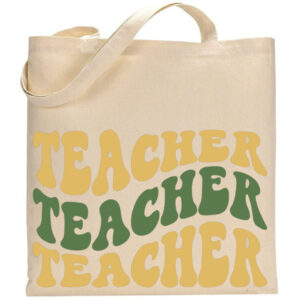 A beige tote bag named "Teacher" features "TEACHER" printed three times in bold, retro yellow and green lettering. - Spruced Studio Upscale Workshop