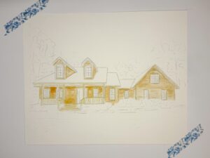 A partially completed watercolor painting of a house, mainly outlined in pencil with some sections filled in with yellow and brown, taped to a white surface with blue-patterned tape. - Spruced Studio Upscale Workshop
